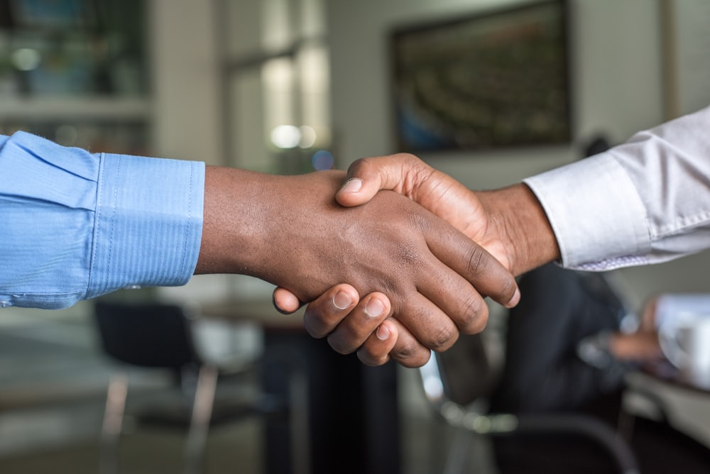 Dos personas estrechando la mano en señal de acuerdo y confianza